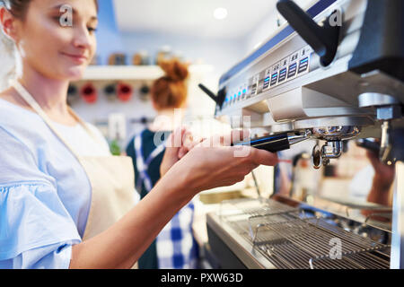 Female barista making coffee at a cafe Stock Photo