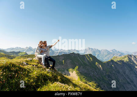 Germany, Bavaria, Oberstdorf, family with little daughter on a hike in the mountains having a break looking at view Stock Photo