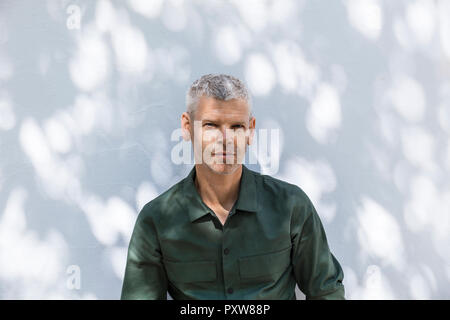 Portrait of a confident mature man at white wall Stock Photo