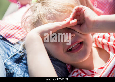 Portrait of happy girl lying on mother's lap Stock Photo