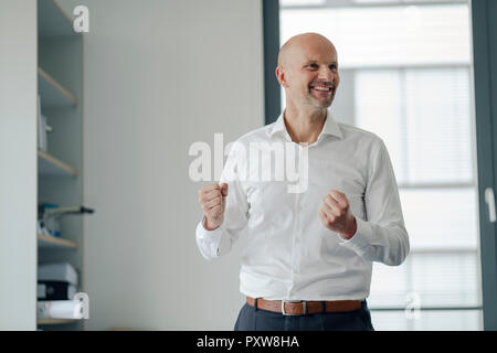 Successful businessman laughing in office Stock Photo