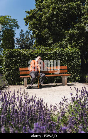 Senior man sitting on park bench, waiting Stock Photo