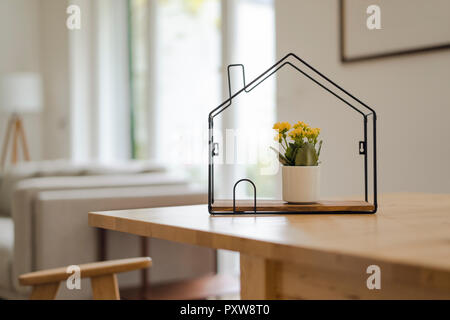 House model with potted flower inside on table Stock Photo