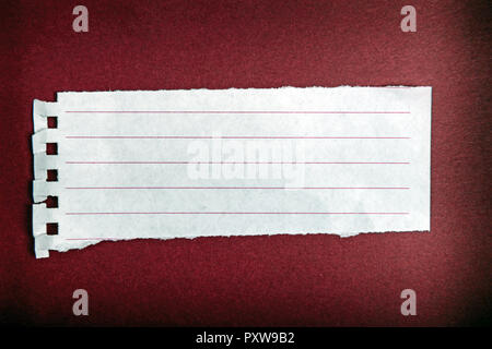 Turn notebook paper on dark red background Stock Photo