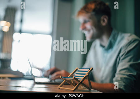 Young man booking vacation, using laptop Stock Photo
