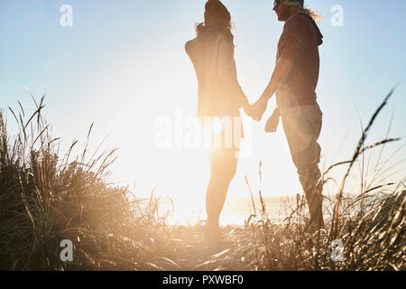 Portugal, Algarve, couple watching the sunset on the beach Stock Photo