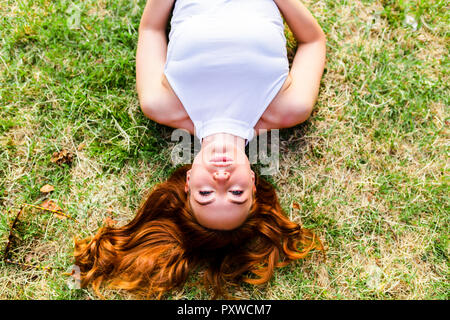 Portrait of redheaded woman lying on a meadow Stock Photo