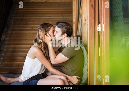 Affectionate couple kissing on balcony Stock Photo