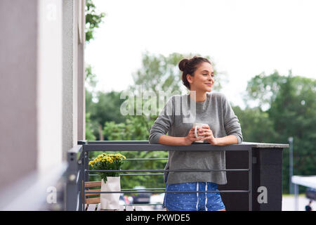 Young woman drinking morning coffee on the balcony Stock Photo