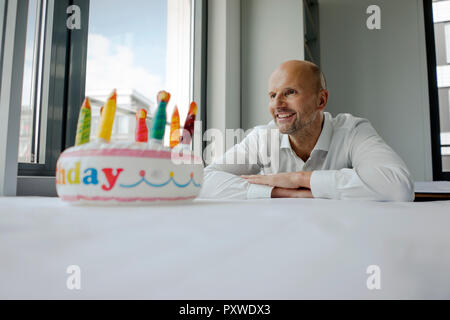 Businessman celebrating his birthday in the office, making a wifh Stock Photo