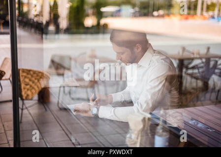Businessman in a cafe taking notes Stock Photo