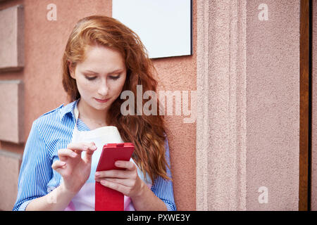 Young woman using a cell phone during a work break Stock Photo