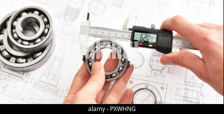 Quality control in modern mechanical engineering - caliper gauges, technical drawing and ball bearings on white background Stock Photo