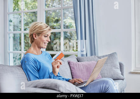 Happy woman at home shopping online Stock Photo
