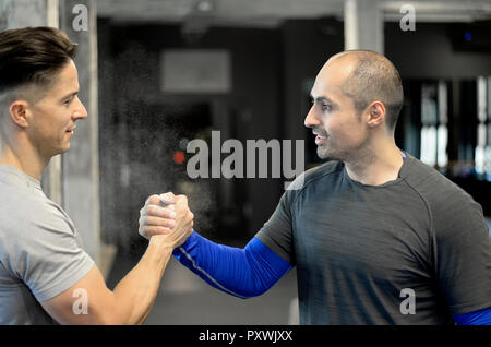 Two men shaking hands in gym Stock Photo