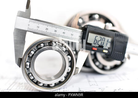 Quality control in modern mechanical engineering - caliper gauges, technical drawing and ball bearings on white background Stock Photo