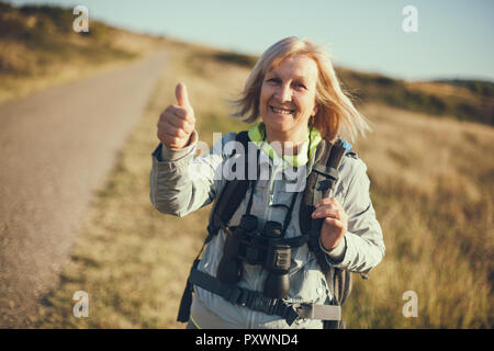 Senior woman is hiking in mountain. Active retirement. Stock Photo
