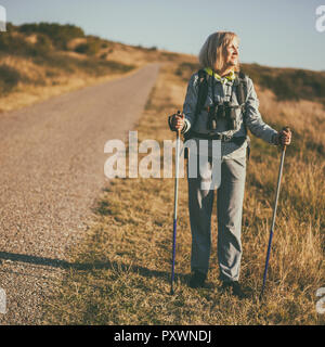 Senior woman is hiking in mountain. Active retirement. Stock Photo