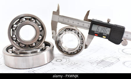 Quality control in modern mechanical engineering - caliper gauges, technical drawing and ball bearings on white background Stock Photo