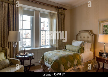 Luxurious bedroom decorated with gold and silk and with a New York City sky view. Stock Photo