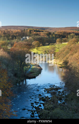 Sunny autumn high view over scenic River Wharfe, looking upstream to Barden Tower ruins & blue sky - Bolton Abbey Estate, Yorkshire Dales, England, UK
