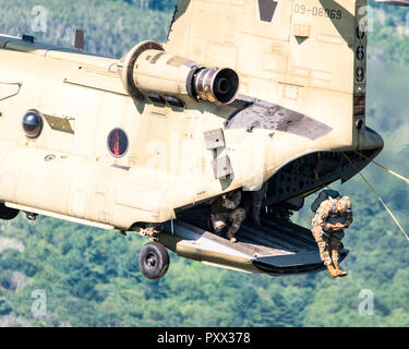 Soldier jumping out of a Chinook at Leapfest 2018, an international static line parachute training event and competition. Stock Photo