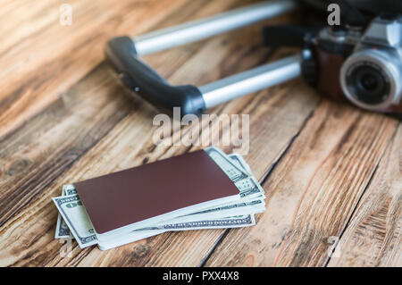 Blank passport and camera with US dollars on wood table ,sun flare filter effect Stock Photo
