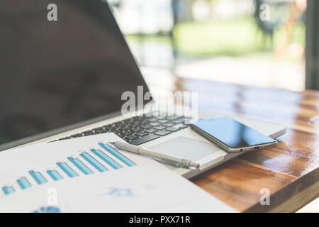 Financial charts on the table with laptop  ( Filtered image processed vintage effect. ) Stock Photo