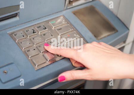 Finger pressing password number on ATM machine Stock Photo