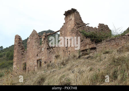 The remains of an old abandoned stone hut in the Pyrenees mountains in Mallos de Riglos, in Aragon region, Spain, during a cloudy autumn day Stock Photo