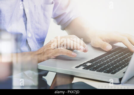 Man's hands typing on laptop keyboard Stock Photo