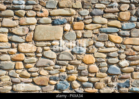 Ancient wall from big colourful round stones Stock Photo