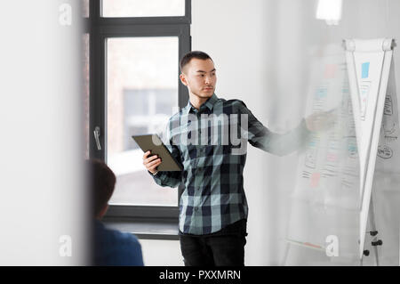 man showing tablet pc to creative team at office Stock Photo