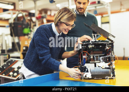 Young attractive students of mechatronics working on project Stock Photo