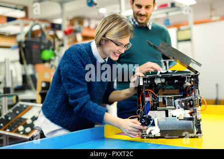 Young attractive students of mechatronics working on project Stock Photo