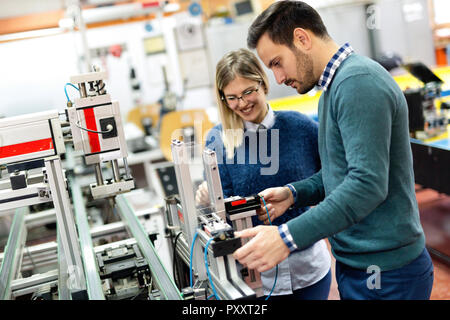 Young attractive students of mechatronics working on project Stock Photo