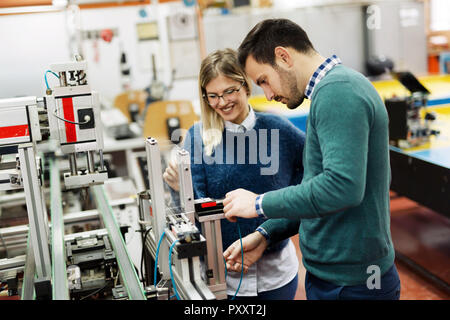 Young attractive students of mechatronics working on project Stock Photo