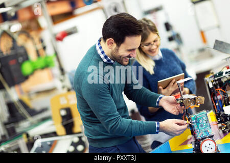 Young attractive students of mechatronics working on project Stock Photo