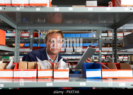 Portrait Of Factory Worker Using Digital Tablet In Store Room Stock Photo