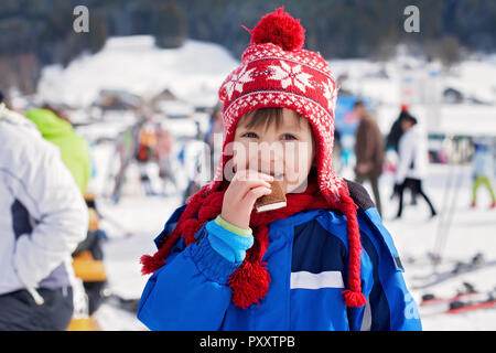 Cute little boy, skiing happily in Austrian ski resort in the mountains, wintertime Stock Photo