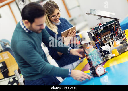 Young attractive students of mechatronics working on project Stock Photo