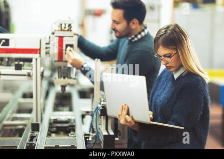 Young attractive students of mechatronics working on project Stock Photo