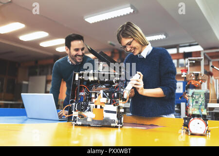 Young attractive students of mechatronics working on project Stock Photo