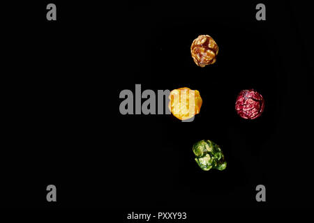multicolored caramel popcorn on a black background. Stock Photo