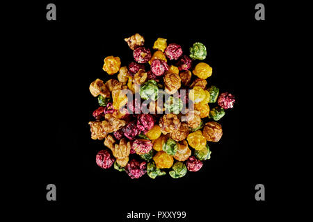 multicolored caramel popcorn on a black background. Stock Photo