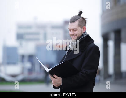 businessman reading documents standing on a city street. Stock Photo