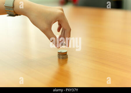 Hand putting coin on coins stack with Savings, Finance concept. Stock Photo