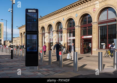 People walking past Cambridge railway station entrance with new electronic information board, Cambridge, UK Stock Photo