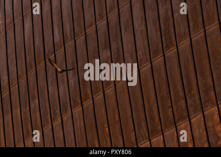 Details of rusty steel structural sheets, used for external roofing surface in organic architectural design. Surface with zinc traces. Stock Photo