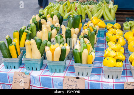 Assorted varieties of summer squash and zucchini on sale at a farmers market. Stock Photo